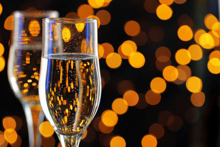 Two glasses of Champagne against bokeh lights backgroundの写真素材