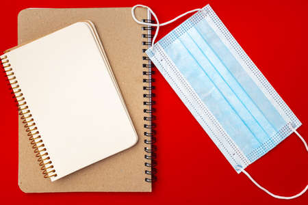 Blank open notepad and medical mask top viewの写真素材