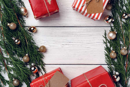 White wooden background with coniferous branches and Christmas decorationsの写真素材