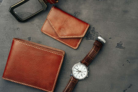 Male watch and leather wallet on dark grey surfaceの写真素材