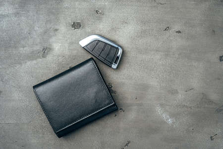 Male leather wallet and car key on dark grey backgroundの写真素材