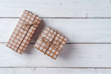 Wrapped Christmas gifts on white wooden board, top viewの写真素材