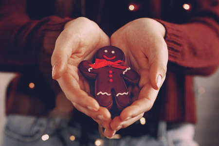 Female hands holding gingerbread man close up