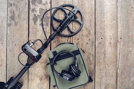 Metal detector tool on wooden board close up