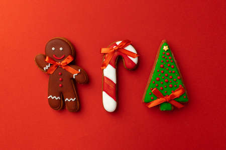 Gingerbread cookies for Christmas celebration on red background