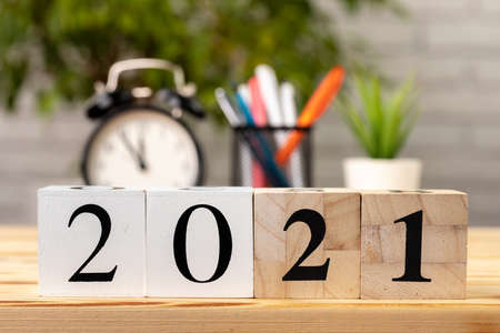Wooden cubes with year 2021 on working table