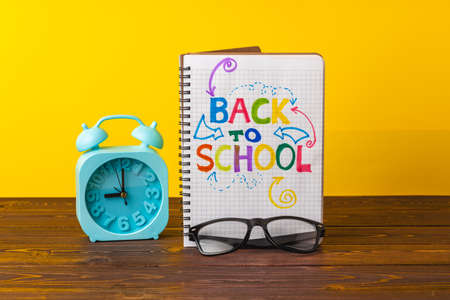 Alarm clock and notepad. Back to school concept