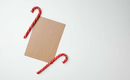 Christmas card and candy canes on white backgroundの写真素材