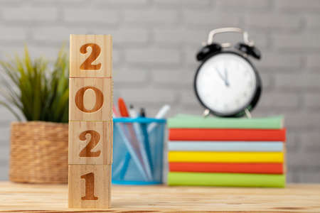 Wooden cubes with year 2021 on working tableの写真素材