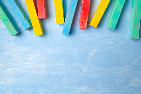 Colorful chalks on blue background with copy space for textの写真素材