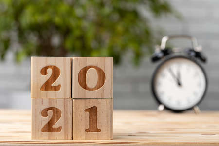 Wooden cubes with year 2021 on working tableの写真素材
