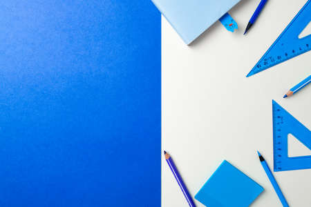 School accessories on blue and white background top view