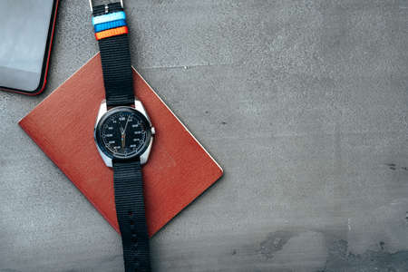 Male watch and notepad on dark grey tableの写真素材