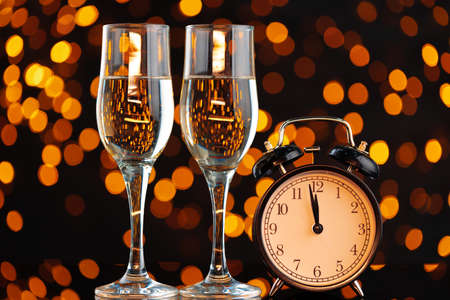 Champagne glass on blurred garland lights background