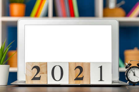 Wooden cubes 2021 Year on working table with open laptop
