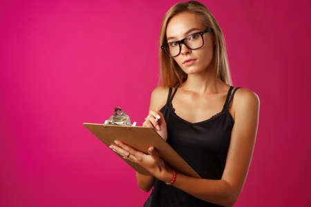 Young beautiful smiling woman standing and holding clipboard
