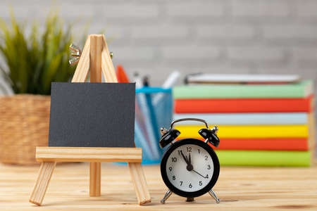 Little black tag on wooden stand on office table. Copy space for your text