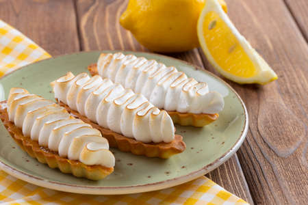 Lemon tart with meringue on green plate