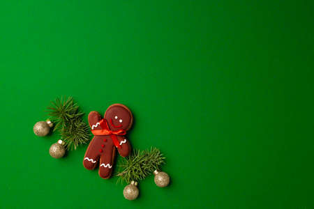 Gingerbread man cookie on green background top view