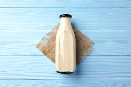 Glass bottle of milk on wooden tableの写真素材