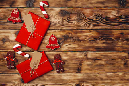 Christmas present and festive gingerbread cookies on wooden background