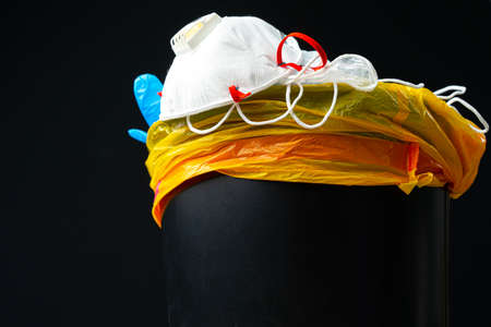 Used infectious masks and medical glove in the trash bin