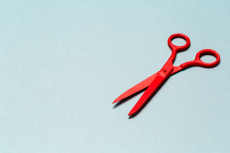 Red scissors on light blue background close upの写真素材