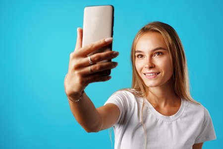 Happy casual young woman smiling and having a video call