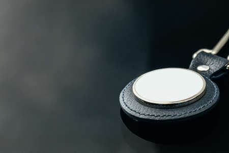Stylish masculine metal key charm on black glass backgroundの写真素材