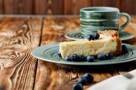 Piece of classic cheesecake on green plate