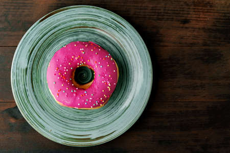 Glazed donut with sprinkles in plate close upの写真素材