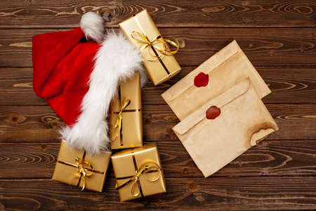 Vintage Christmas greeting letter and wrapped gift boxes on wooden backgroundの写真素材