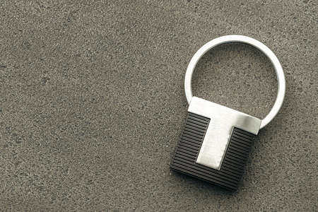 Metal key pendant on dark concrete background