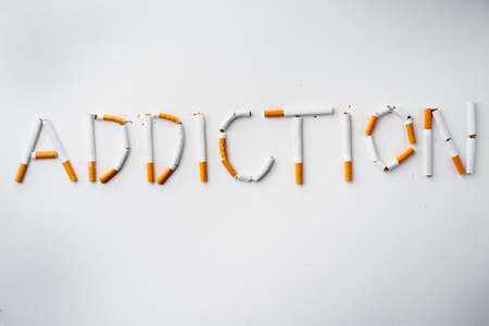 Inscription word ADDICTION made out of cigarettes top viewの写真素材