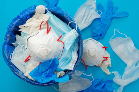 Used infectious masks and medical glove in the trash binの写真素材