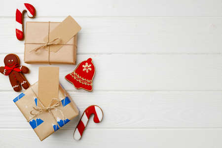 Christmas present and festive gingerbread cookies on wooden background