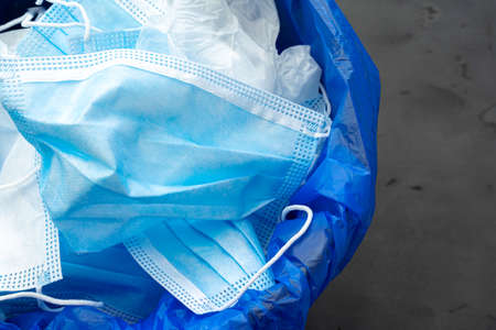 Used infectious masks and medical glove in the trash bin