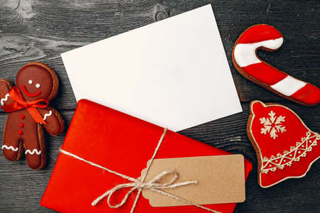 Christmas present and festive gingerbread cookies on wooden background