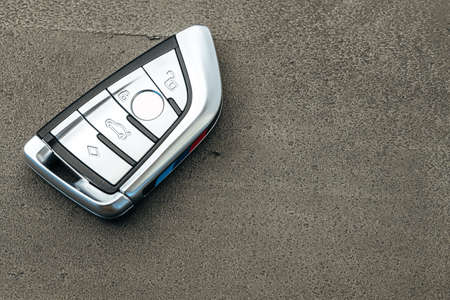 Modern automobile car key on black concrete background
