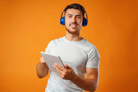 Handsome young mixed-race man listening to music with blue headphones