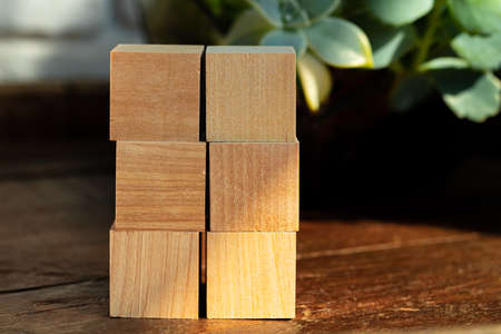 Groupped wooden square blocks on dark wooden table