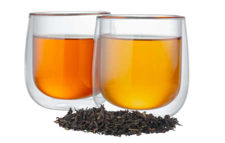 Glass cup of tea with dry tea leaves isolated on whiteの写真素材