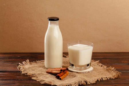 Glass bottle and glass cup with milk front viewの写真素材