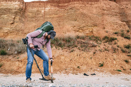 Man with metal detector searching for lost treasures on the beachの写真素材