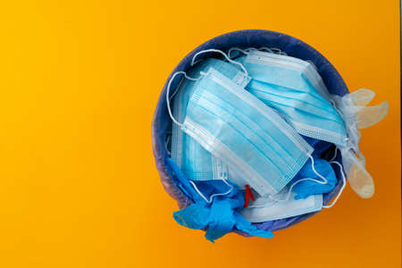 Used infectious masks and medical glove in the trash bin