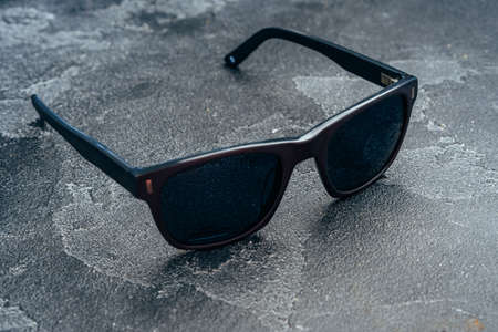 Dark male sunglasses on grey concrete surfaceの写真素材