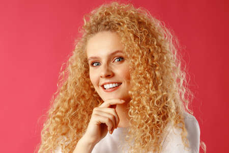 Gorgeous beautiful young woman with curly hair posing at camera