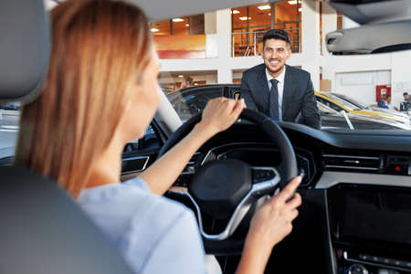 Happy woman new car owner sitting in driver seat