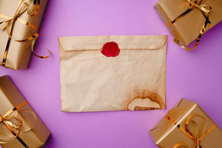 Flatlay composittion with Santa list and wrapped gift boxes on purple background