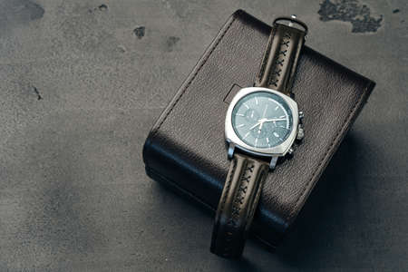 Male watch and leather wallet on dark grey surfaceの写真素材